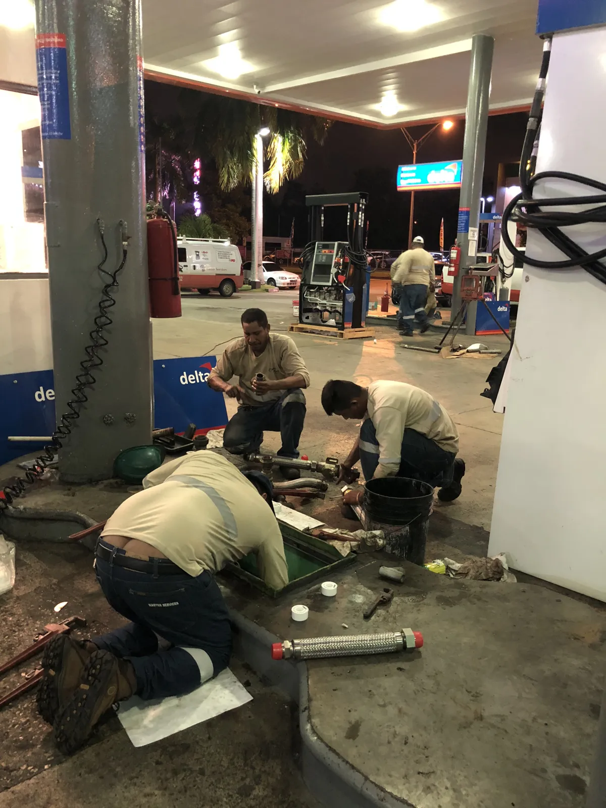 Técnicos trabajando de rodillas en la isla de despacho de noche