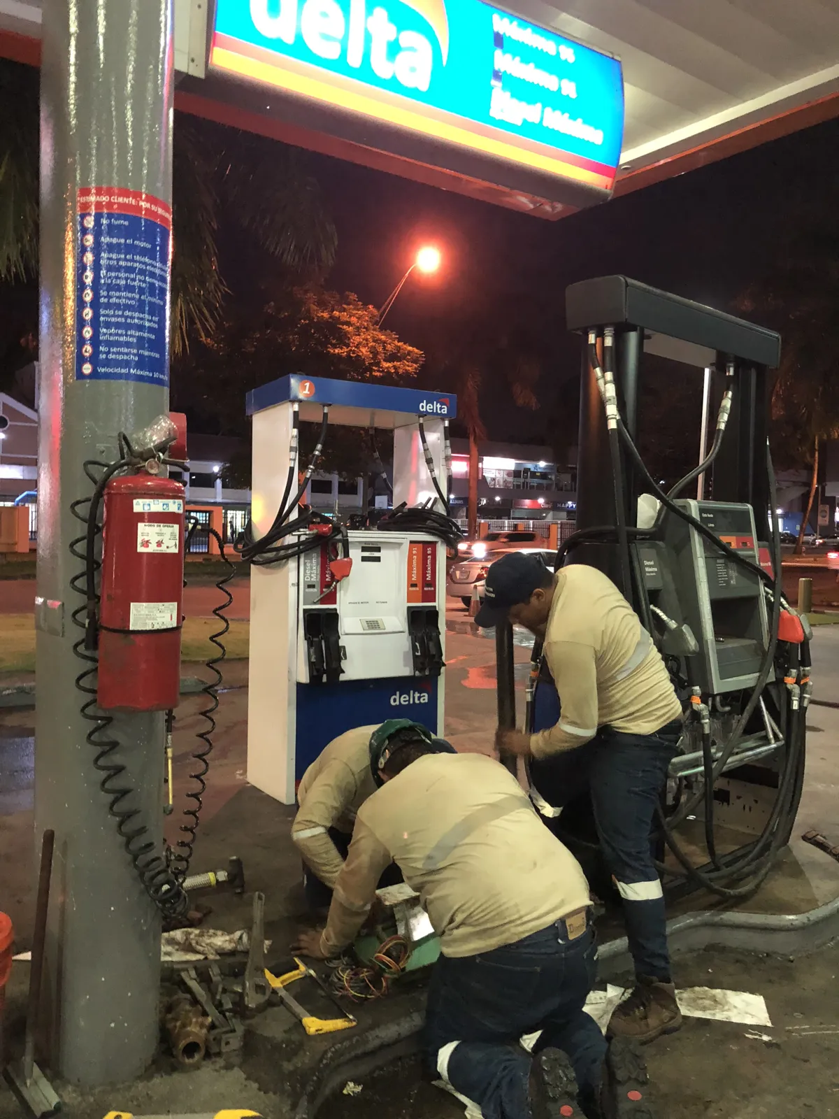 Técnicos montando el dispensador nuevo en la estación Delta de noche