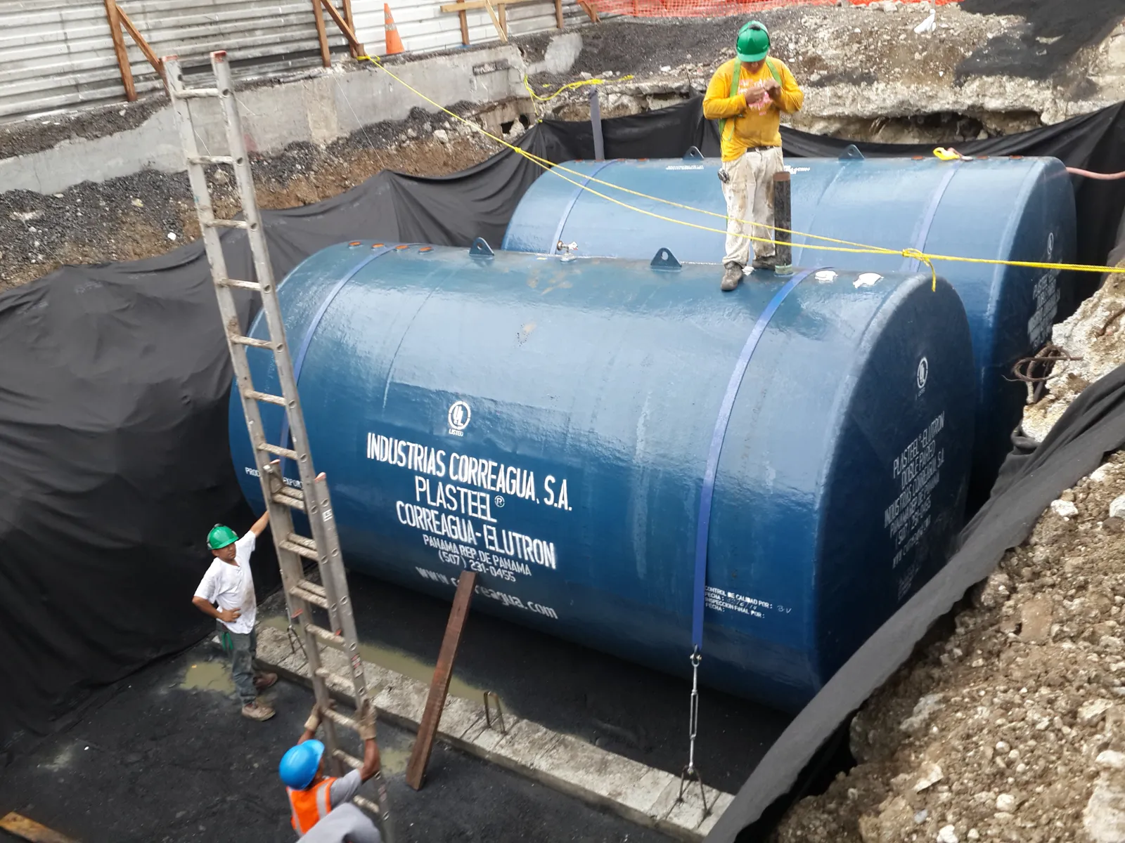 Técnicos sobre el tanque PLASTEEL con escalera durante las conexiones