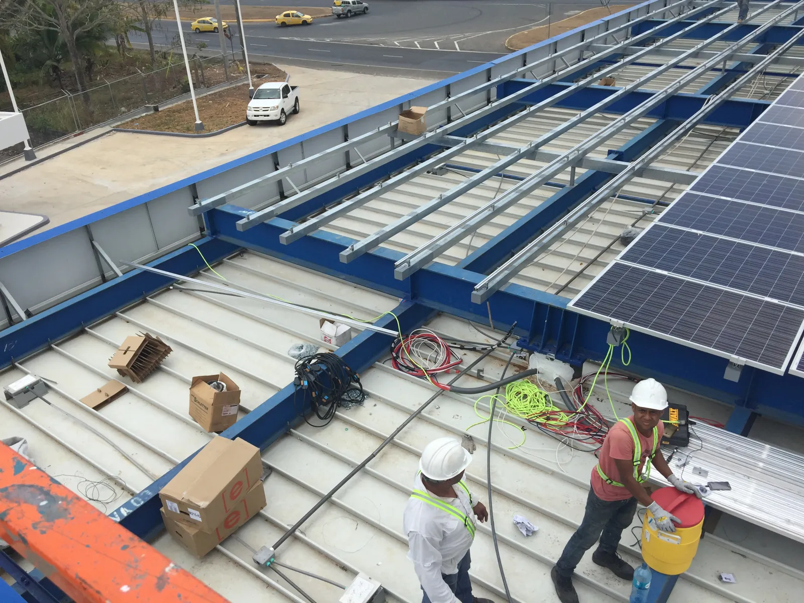 Técnico instalando paneles solares sobre el techo del canopy
