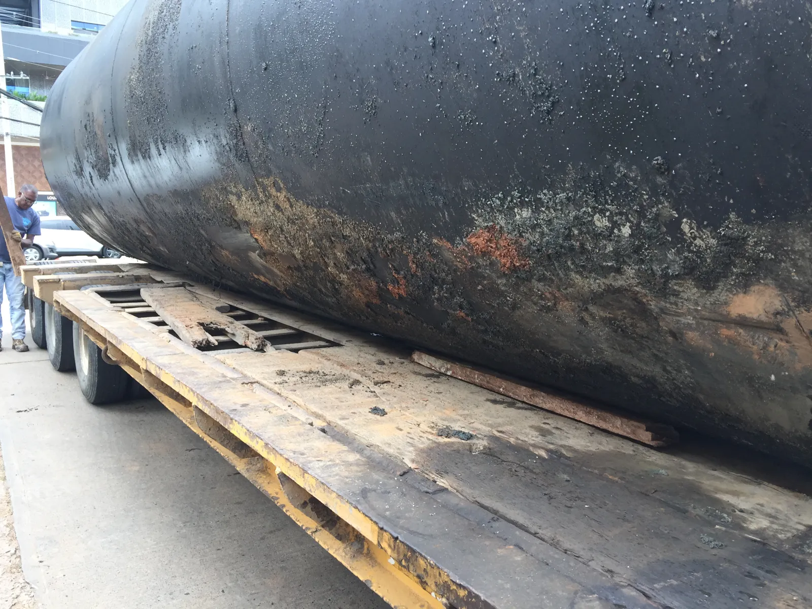 Tanque de acero viejo cargado sobre plataforma para su disposición