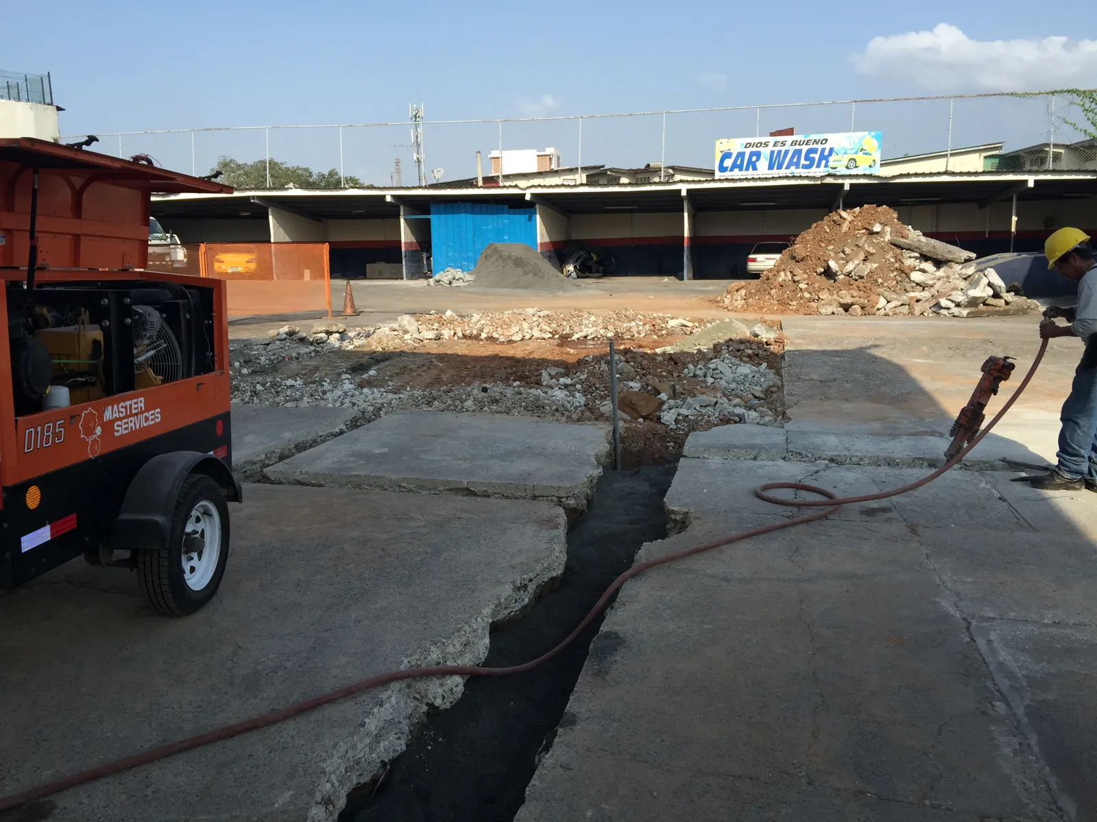 Compresor y pavimento demolido durante la obra en el patio
