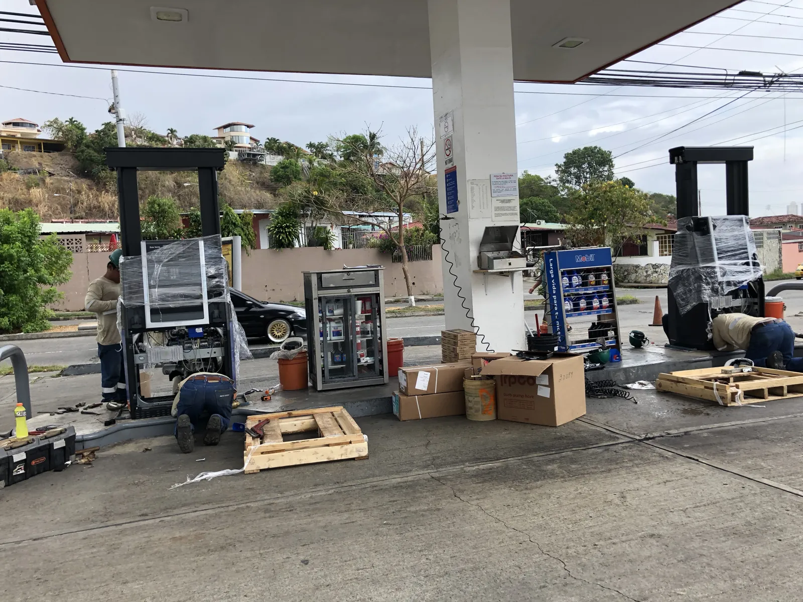 Isla de despacho con el dispensador nuevo en instalación y cajas de equipo