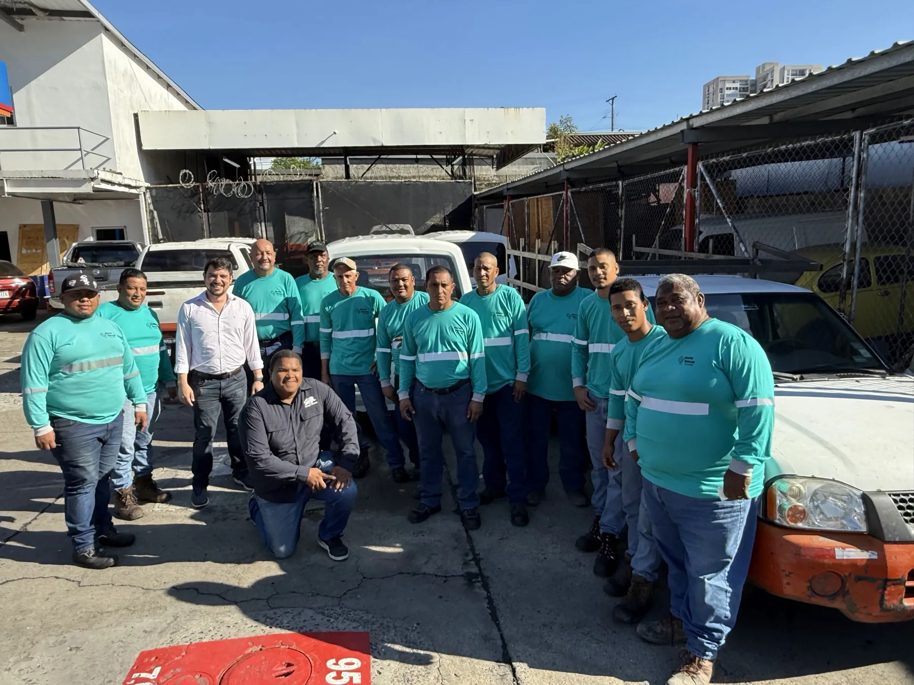 Equipo de Master Services — técnicos de campo en uniforme teal y personal de la empresa posando frente a vehículos y equipo en una estación de servicio de Panamá