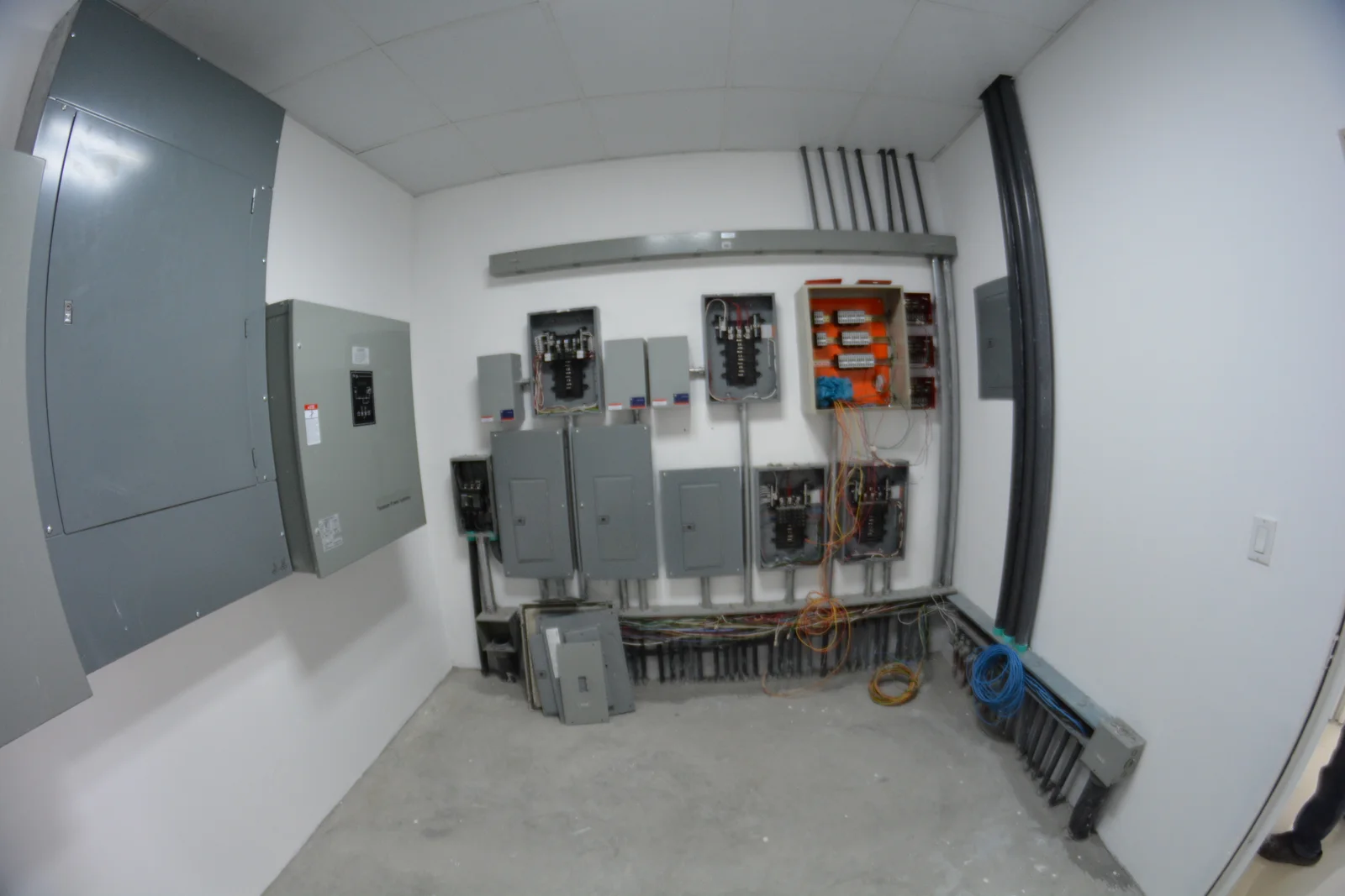 Cuarto eléctrico con tableros abiertos y canalizaciones