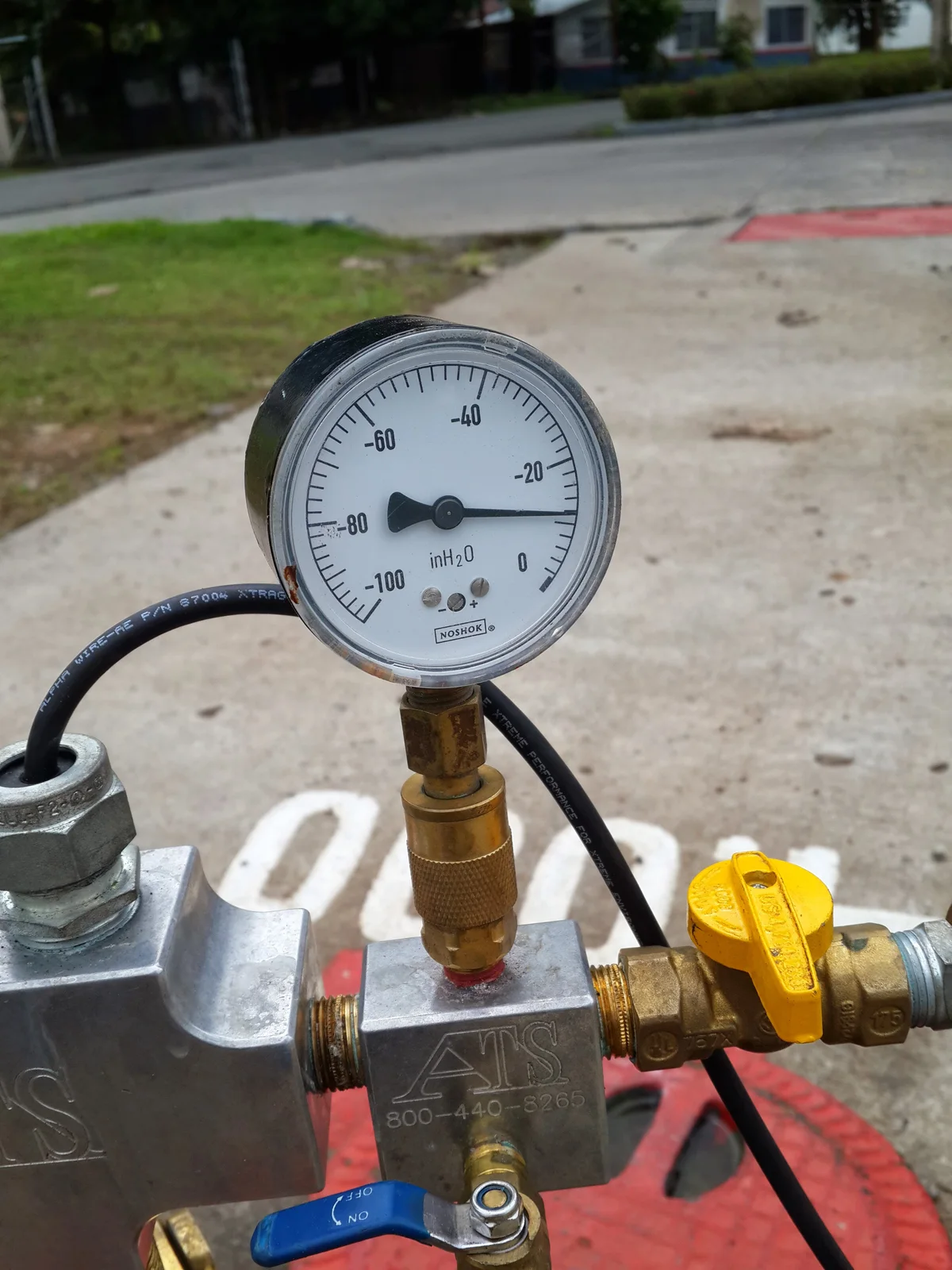 Close-up of a vacuum gauge and valves in an instrumentation assembly