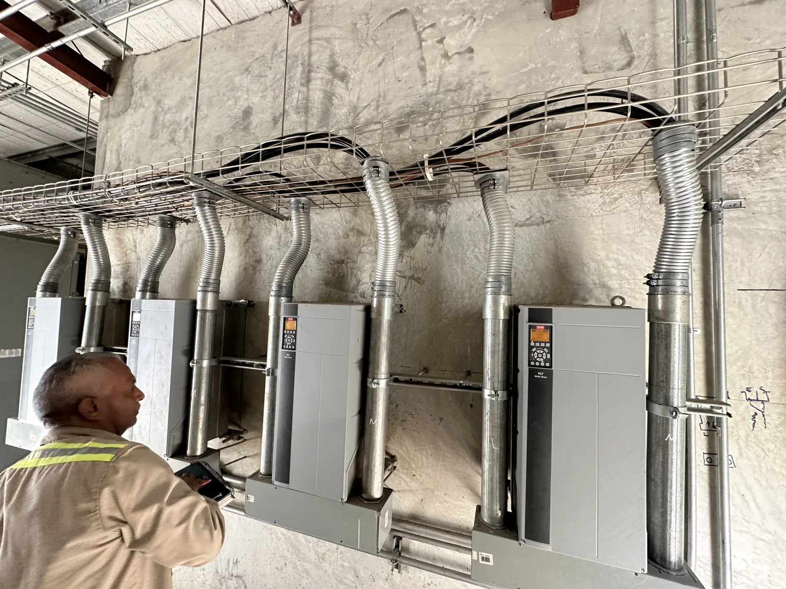 Técnico trabajando en una fila de paneles eléctricos montados en pared
