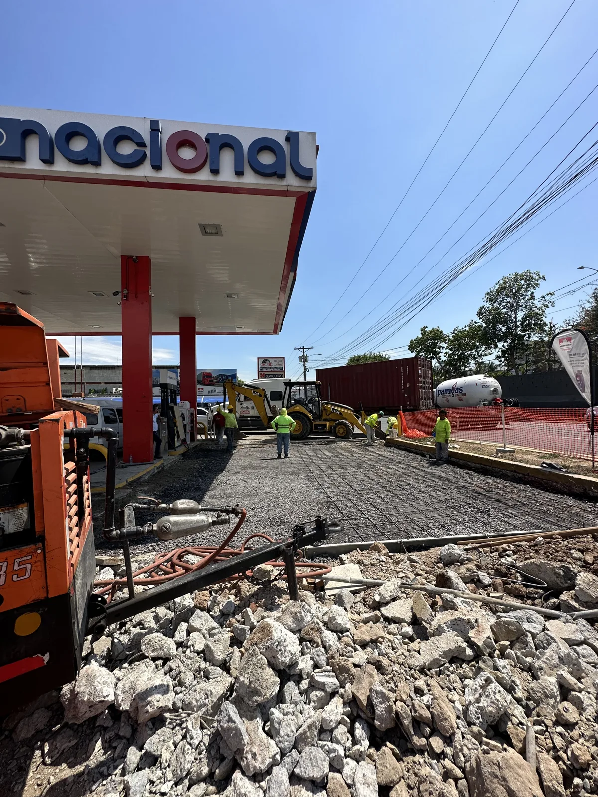 Pavimentación en una estación con la maquinaria y el canopy al fondo