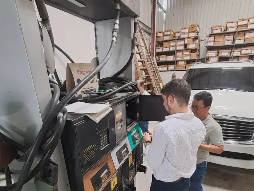 Técnicos de Master Services reparando un dispensador de combustible abierto, con acceso a tarjetas, mangueras y componentes internos